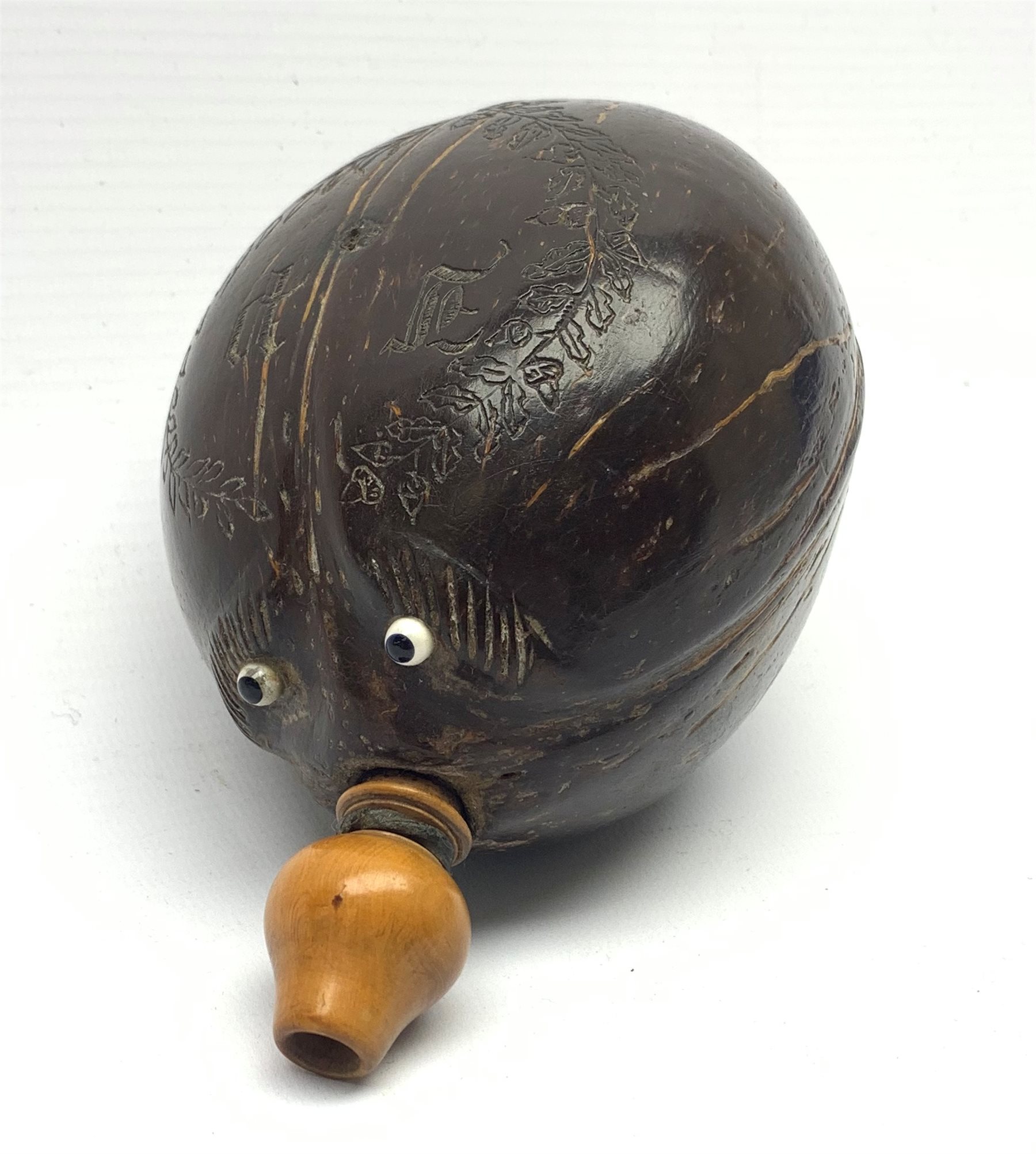 Napoleonic coconut bug bear flask with carved decoration and initials, inset glass eyes and turned b