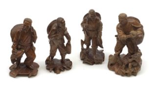 Four Chinese carved wooden figures, modelled as fishermen with their catch, one modelled with birds