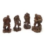 Four Chinese carved wooden figures, modelled as fishermen with their catch, one modelled with birds