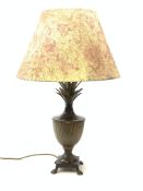 A cast metal table lamp, the base of square form with four pad feet leading to a spreading food, obl