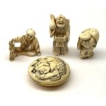 Three Japanese carved ivory netsukes, each modelled as a male figure, seated figure holding a bunch