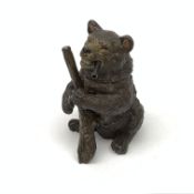 A bronze match holder or vesta, modelled in the form of a bear holding a stick and smoking a cigar,