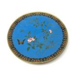 A Japanese cloisonne dish, of circular form, the blue ground decorated with blossoming vines and a b