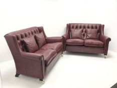 Pair Duresta two seat high back sofas upholstered in deep buttoned maroon leather, ebonised supports