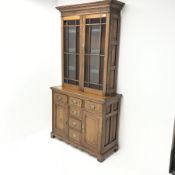 Edwardian oak bookcase on cupboard, two stained glass doors enclosing three shelves above six drawer