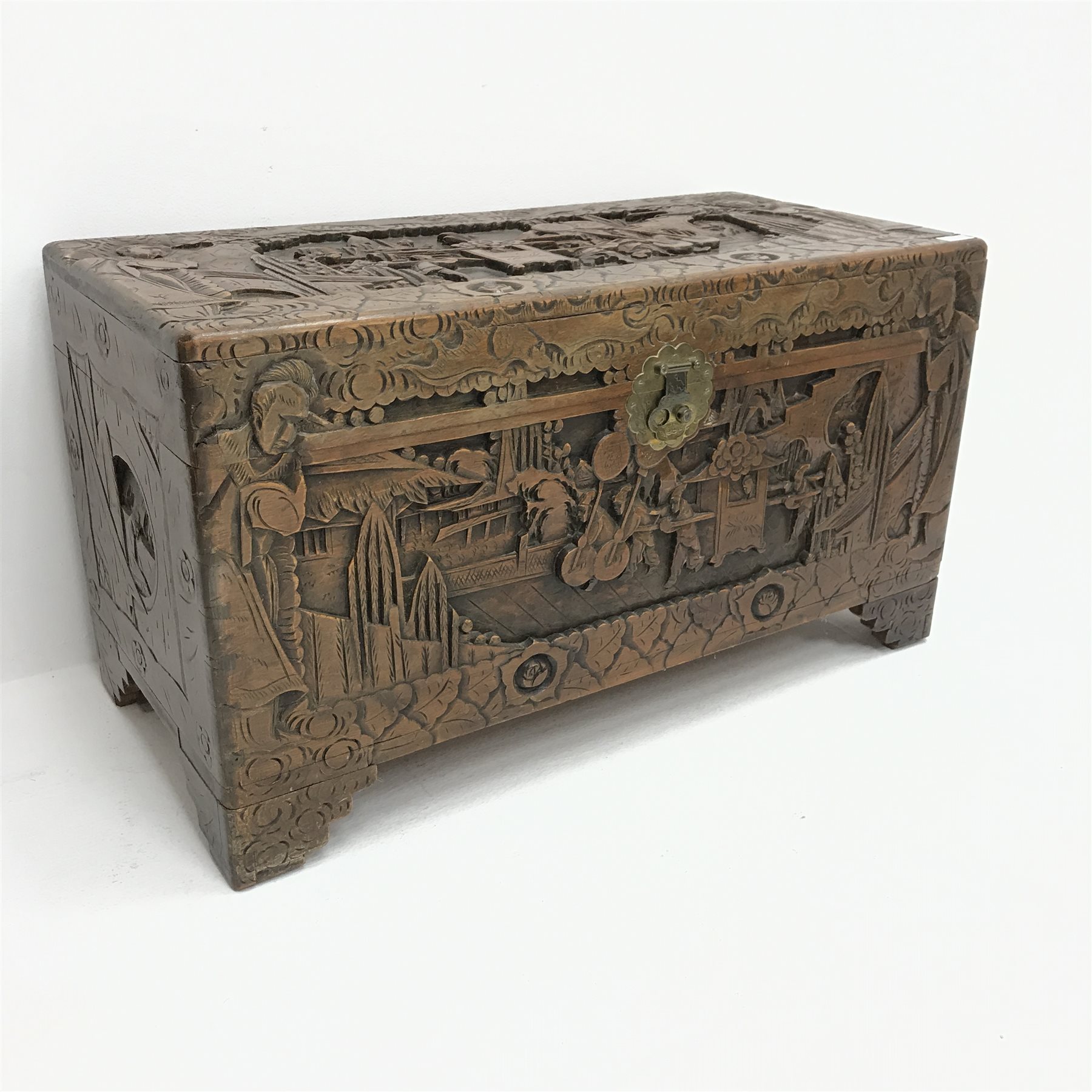 Eastern camphor wood chest, heavily carved depicting figure being carried in a sedan chair, hinged l