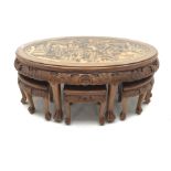 Eastern glass topped oval table decorated in high relief with six integral stools, W124cm, H50cm, D8