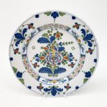 A mid 18th century English Delft plate, painted in polychrome colours with flowers and leaves, D24cm