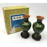 A pair of 20th century cloisonn� vases, of baluster form, the dark green ground decorated with flowe