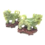 A pair of carved jade dogs of fo, each upon shaped wooden stand, figures H9.5cm.