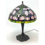 A Tiffany style table lamp, with cast spreading base detailed with flowers, and leaded glass shade,
