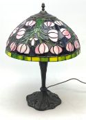 A Tiffany style table lamp, with cast spreading base detailed with flowers, and leaded glass shade,