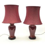 A pair of burgundy ceramic lamps, of baluster form, with matching burgundy shades, overall H71cm.