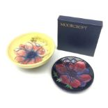 A Moorcroft dish, decorated with the Clematis pattern upon a yellow ground, with paper label beneath