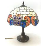 A Tiffany style table lamp, with cast spreading base detailed with tendrils, and leaded glass shade,