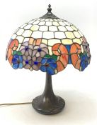 A Tiffany style table lamp, with cast spreading base detailed with tendrils, and leaded glass shade,