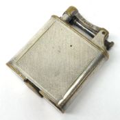 A Dunhill silver plated cigarette lighter, with engine turned panels to the body, marked to arm Dunh