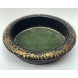 A Regency black papier mache wine coaster, with gilt foliate detail to rim, D14.5cm.