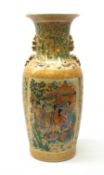 A large japanese vase, the yellow ground decorated with figural panels containing geishas within a m