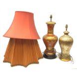 A large table lamp, of baluster form the red ochre ground with gilt foliate detail, with shade, lamp