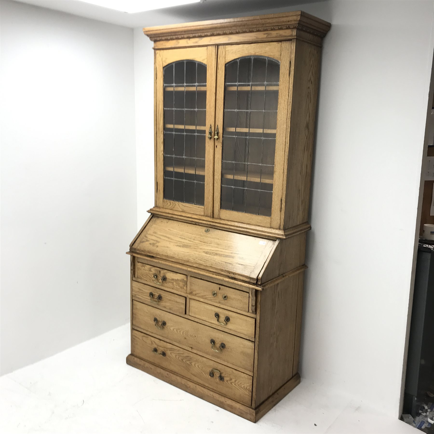 Early 20th Century light oak bureau bookcase, two lead glazed doors, three adjustable shelves above