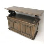 Early 20th century oak monks bench, tilt top, carved lion arms, hinged seat, plinth base, W107cm, H7