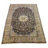 Persian Nain carpet, floral design on dark blue field, central rosette medallion, ivory ground outer