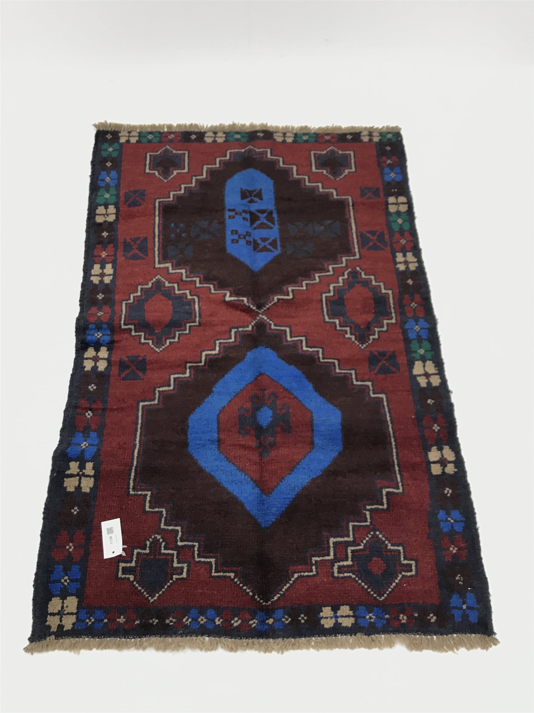 Baluchi red and blue ground rug, two medallions, 130cm x 83cm