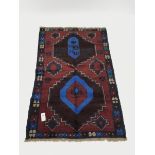 Baluchi red and blue ground rug, two medallions, 130cm x 83cm