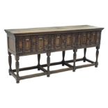 17th century style oak sideboard, three large drawers, heavily carved front, on tapering supports c