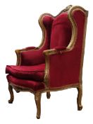 French upholstered wing back chair, the gilt frame with scroll carved cresting and acanthus arms, s