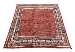 Large Persian Araak rug carpet, the red field decorated with repeating boteh motifs, multiple band b