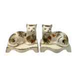 Pair of 19th century Staffordshire cats, modelled in recumbent pose, upon bases with bracket feet, l