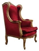 French upholstered wing back chair, the gilt frame with scroll carved cresting and acanthus arms, s