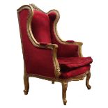French upholstered wing back chair, the gilt frame with scroll carved cresting and acanthus arms, s