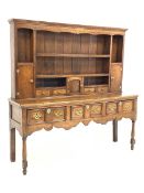 George III oak dresser, dentil cornice over open shelves and cupboards, three drawers under, raised