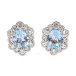 Pair of 18ct white gold oval aquamarine and diamond cluster stud earrings, hallmarked, total aquamar
