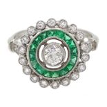 Platinum round diamond and calibre cut emerald target design ring, with diamond set shoulders