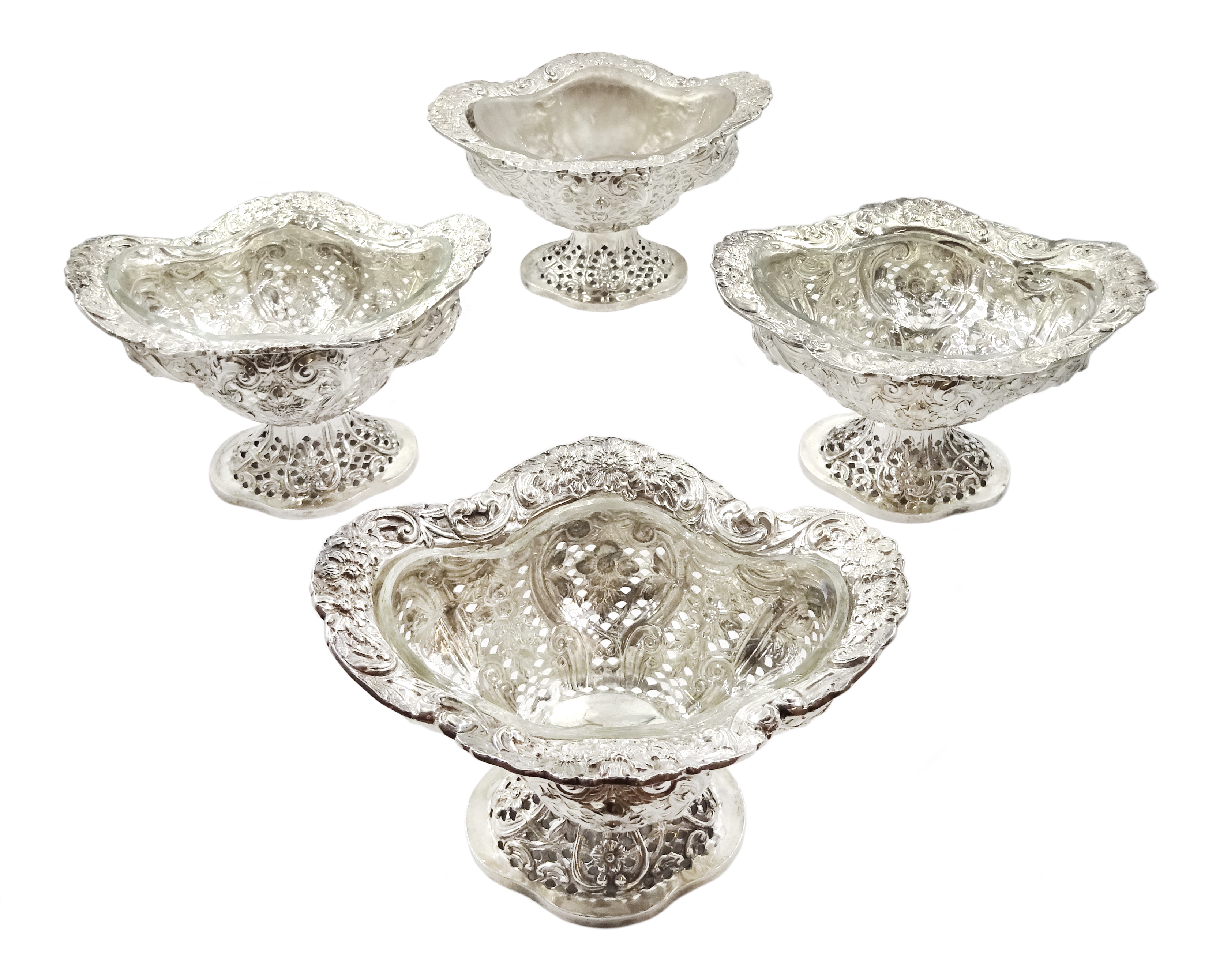 Four Victorian silver pedestal bon bon dishes, embossed foliate and pierced decoration, with glass l