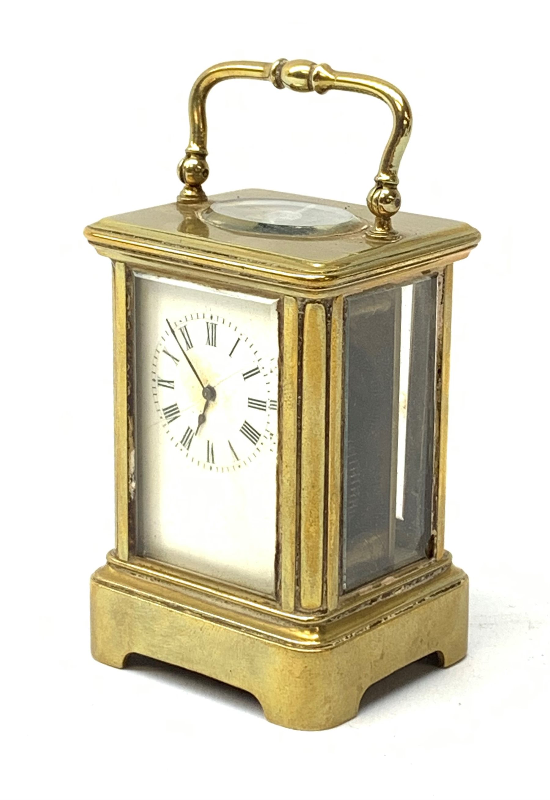 A brass cased miniature carriage clock, the white enamel dial with black Roman numerals, H7cm.