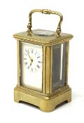 A brass cased miniature carriage clock, the white enamel dial with black Roman numerals, H7cm.