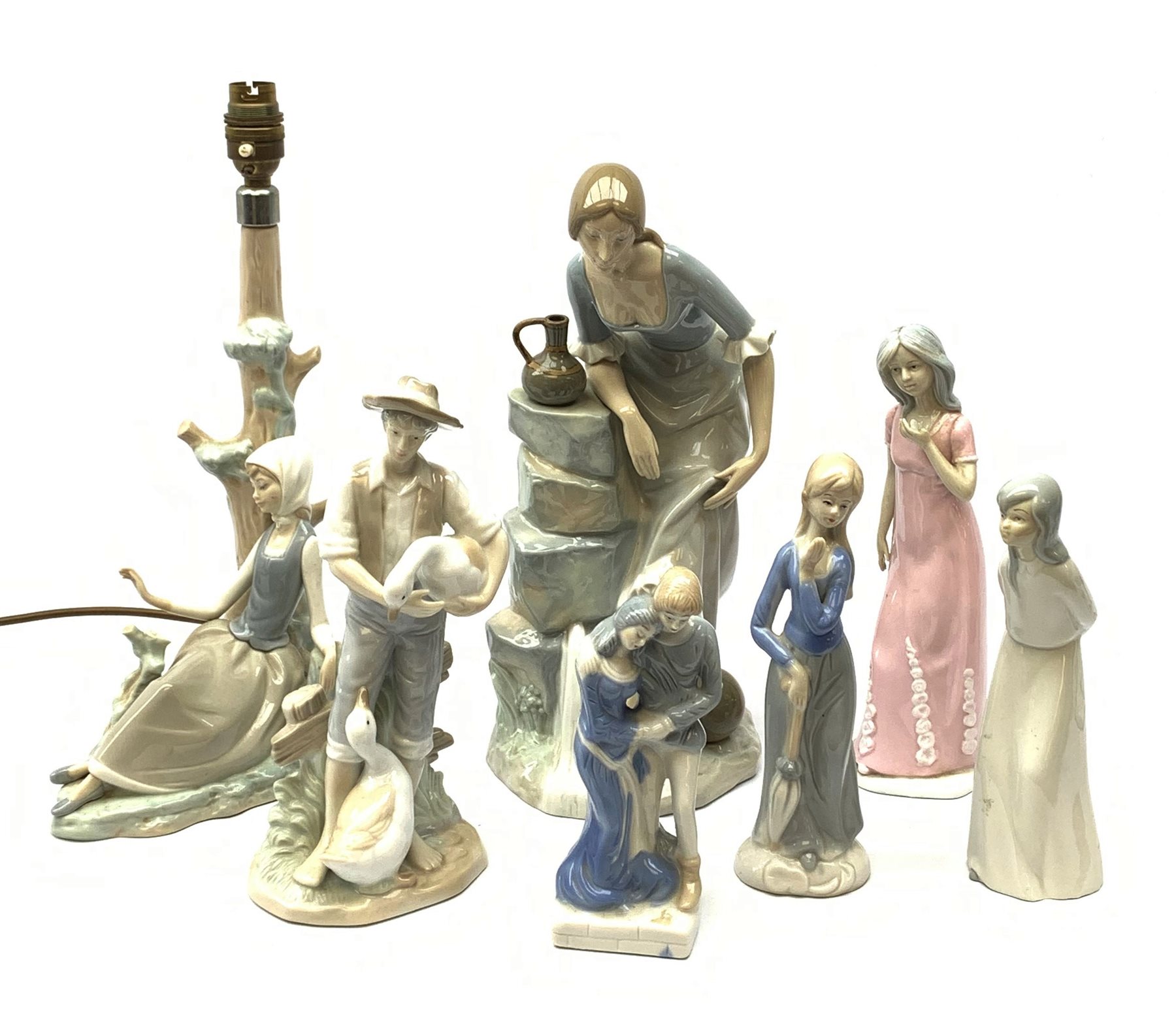 A group of figurines, to include a large Nao example, H32.5cm, and a Lladro table lamp, (a/f).