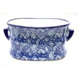 A modern blue and white transfer printed prunus blossom pattern footbath, with twin carry handles, L