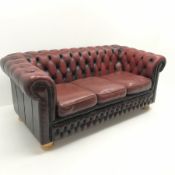 Three seat Chesterfield sofa upholstered in deep buttoned Ox blood leather, turned supports, W185cm