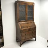 Early 20th century bookcase on bureau, two lead glazed doors above single fall front enclosing fitte