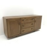 Ercol light elm sideboard, two cupboards flanking three drawers, W156cm, H69cm, D45cm