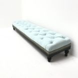 Early 20th century ebonised long low footstool, upholstered in a deep buttoned sky blue fabric, turn