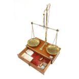 A fine take down brass balance by AVERY with brass pans on mahogany single drawer stand with a few