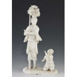 A 9" ivory okimono of a mother carrying carrying a bundle of sticks being handed a butterfly
