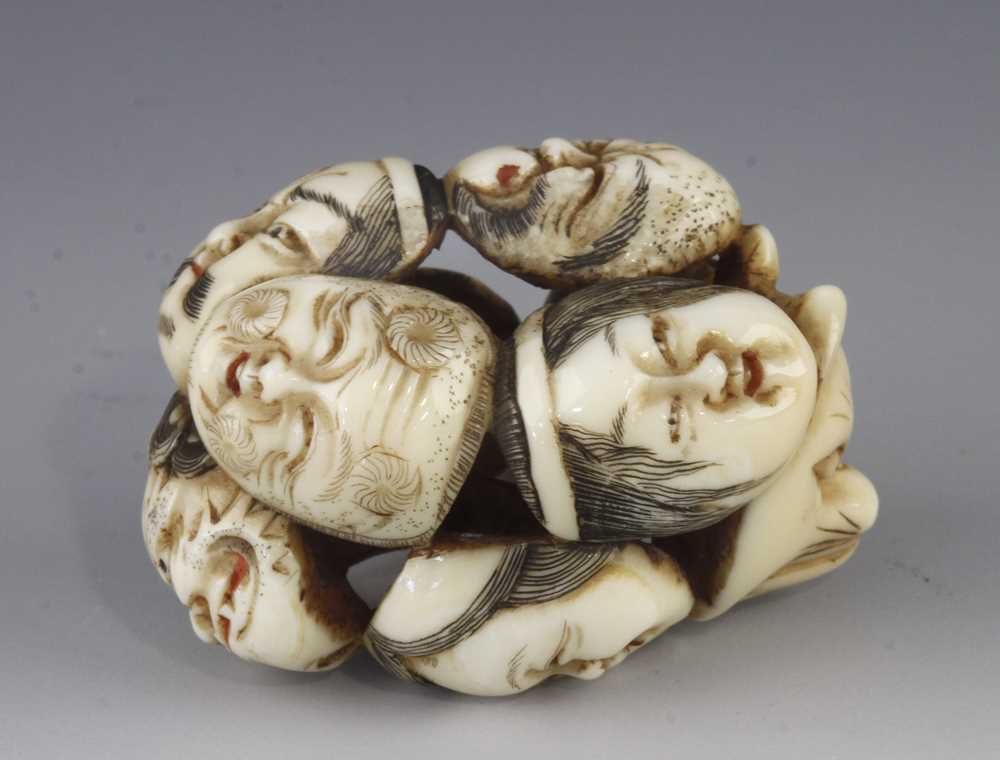 An ivory netsuke of 9 Noh masks